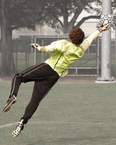 Goleiro pulando na bola